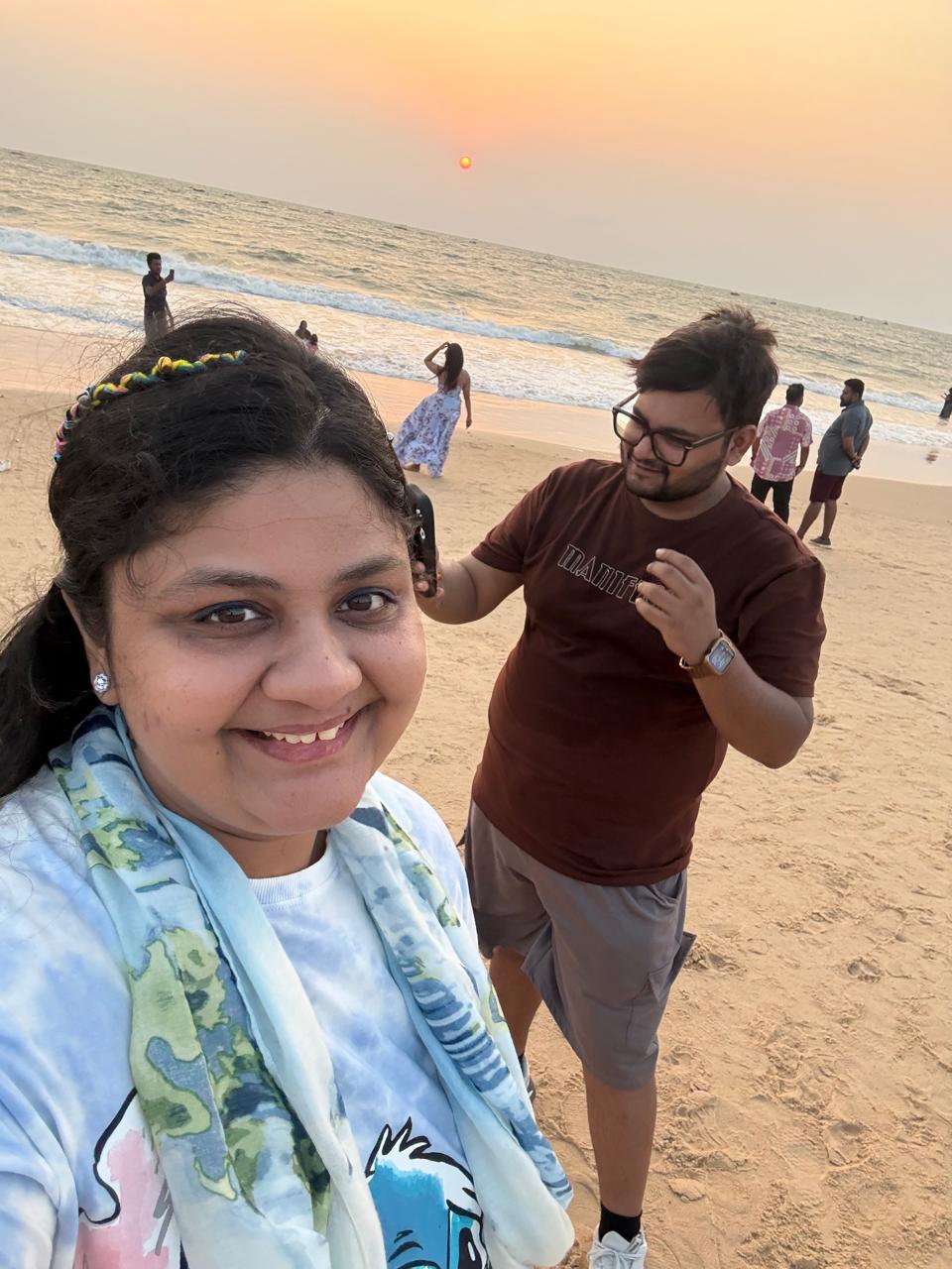 Salil and Eesha smiling together on a Goa beach at sunset