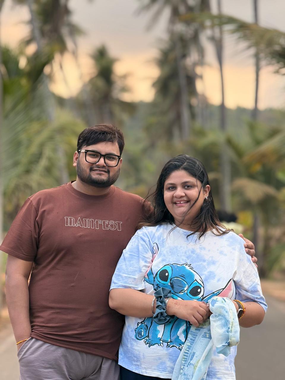 Salil and Eesha standing together near palm trees