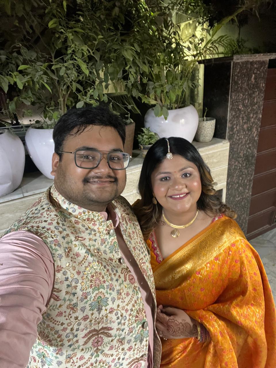 Salil and Eesha smiling in festive outfits at night