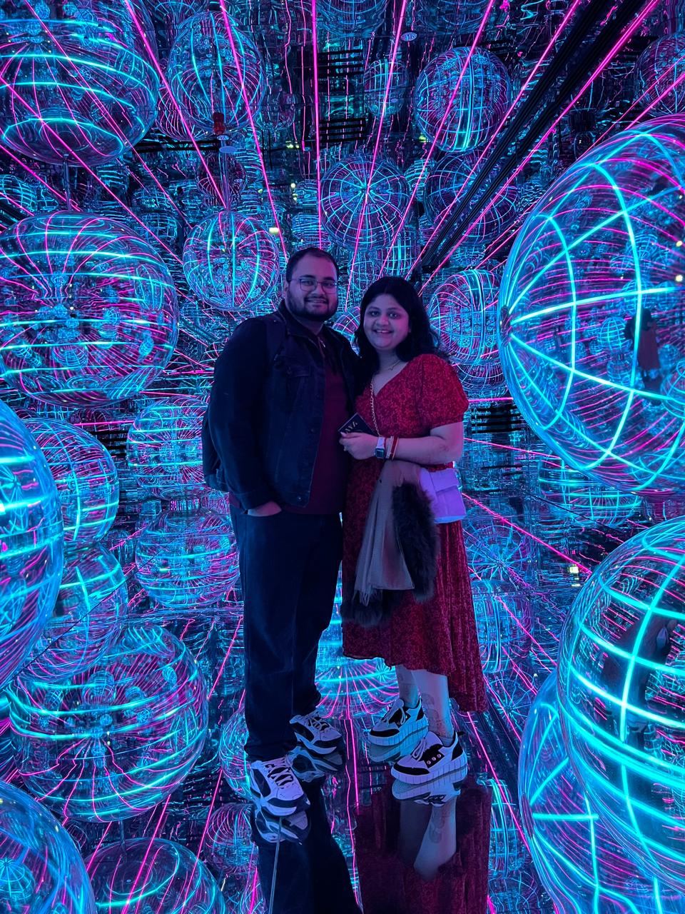 Salil and Eesha standing inside a neon light installation