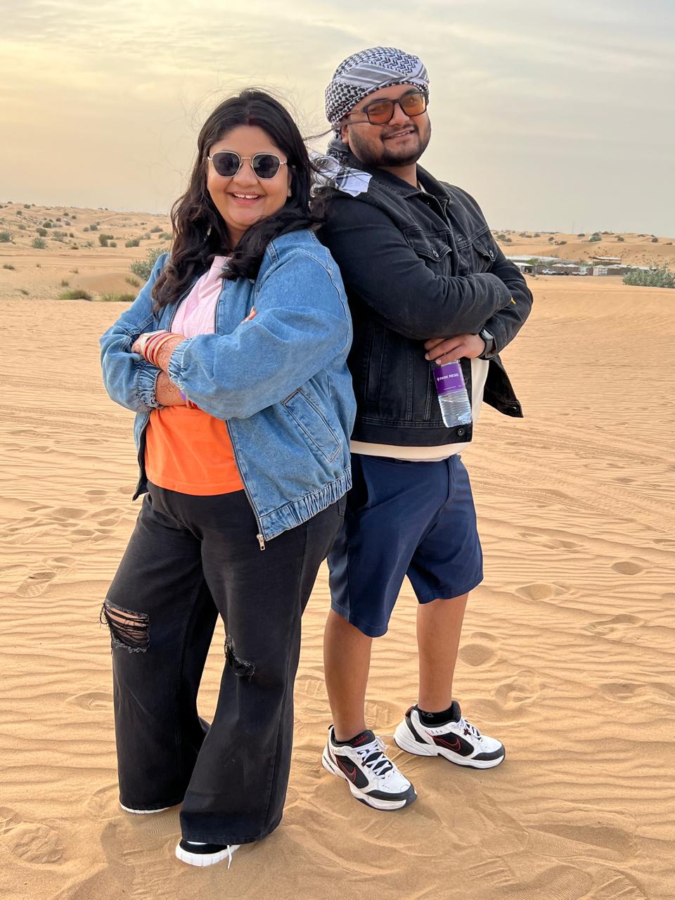 Salil and Eesha standing back to back in the desert