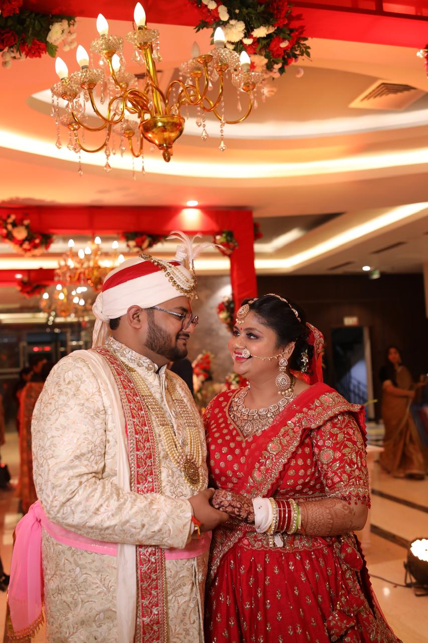 Salil and Eesha looking at each other in wedding outfits