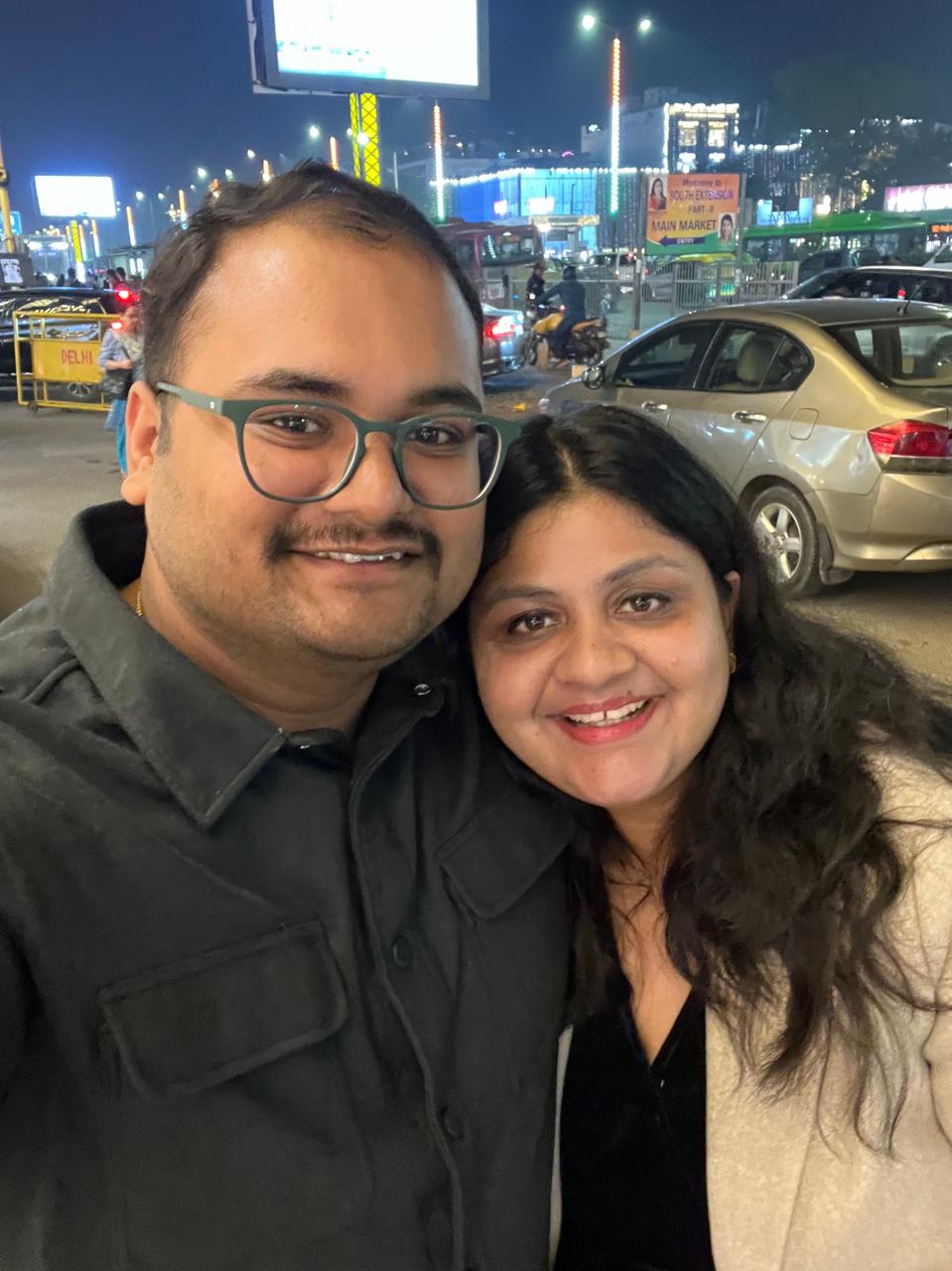 Salil and Eesha smiling in a night-time selfie